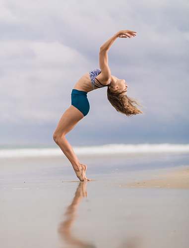 dance pose woman standing on seashore during daytime leisure activities